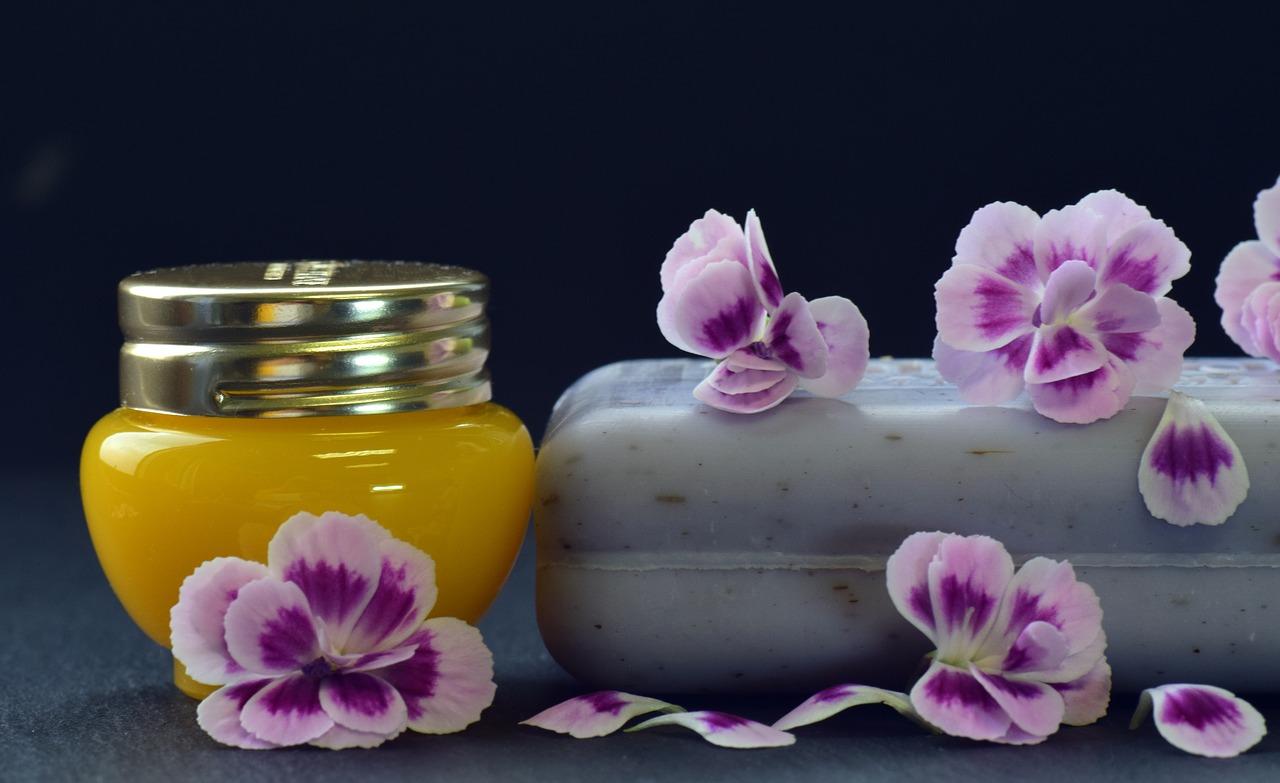 A jar of honey next to some flowers