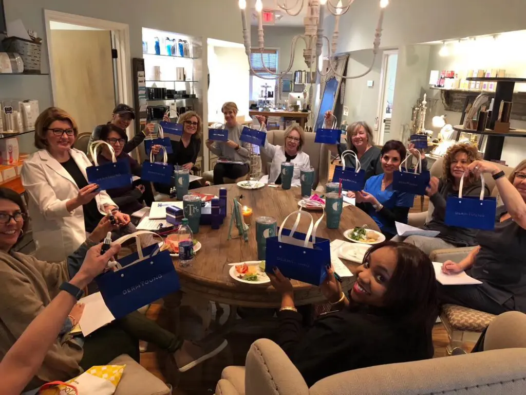 A group of people sitting around a table with bags.