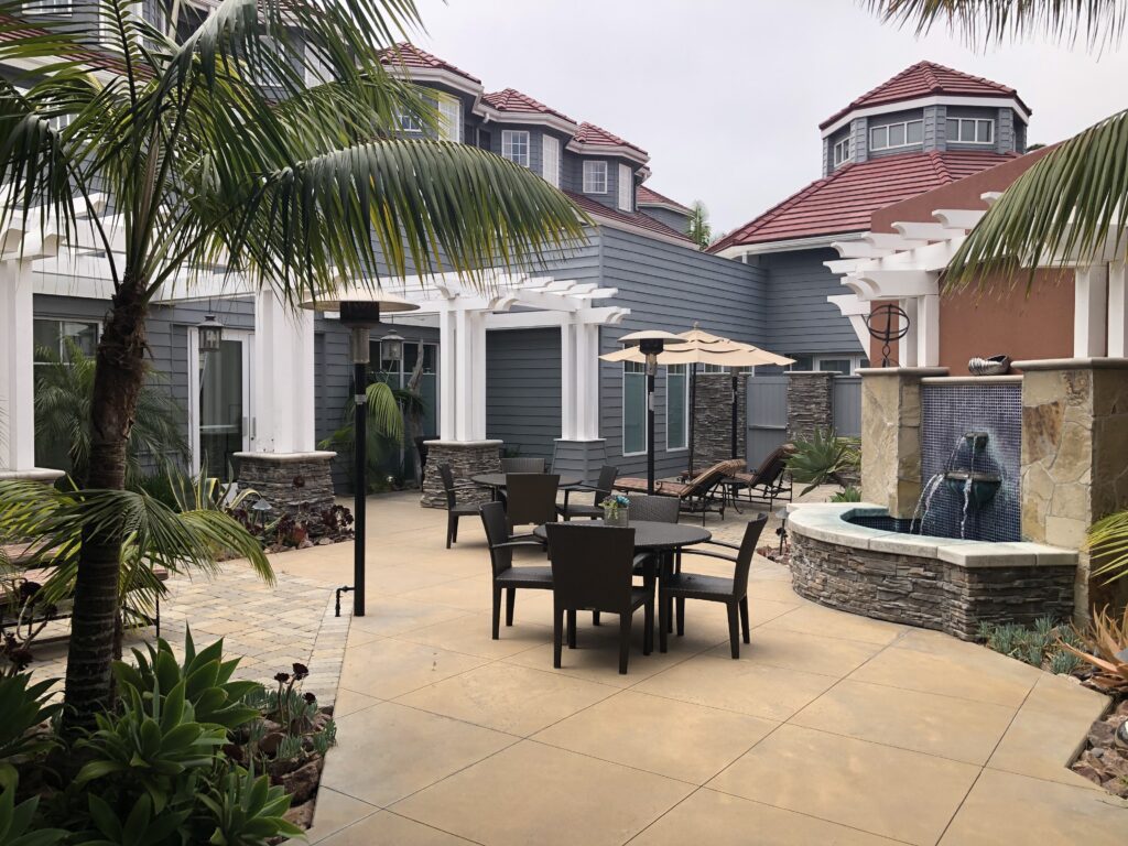 A patio with tables and chairs outside of a house.