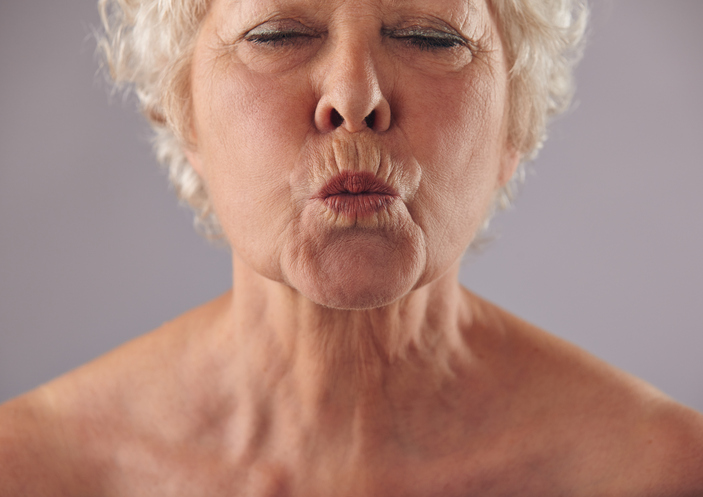 A woman with white hair is making an odd face.