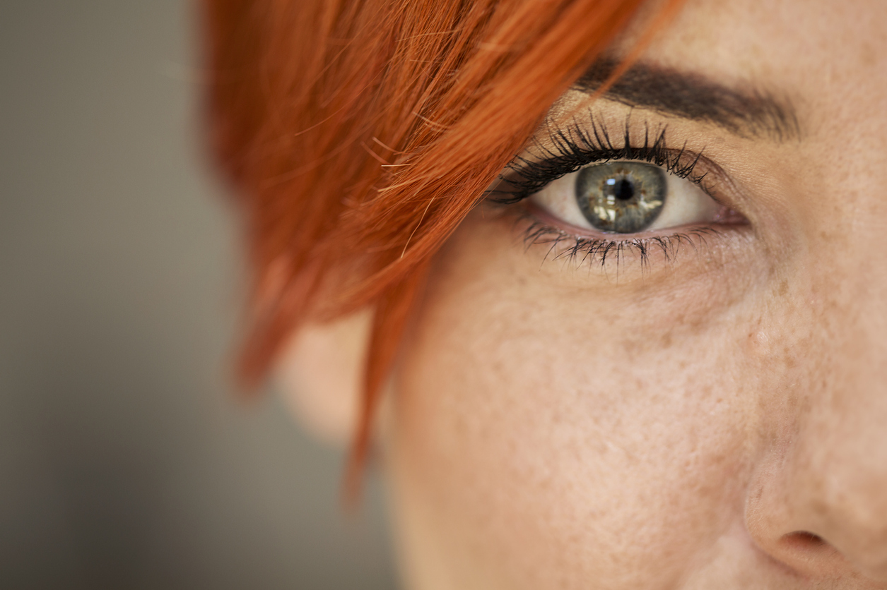 A close up of the eye of a person with red hair