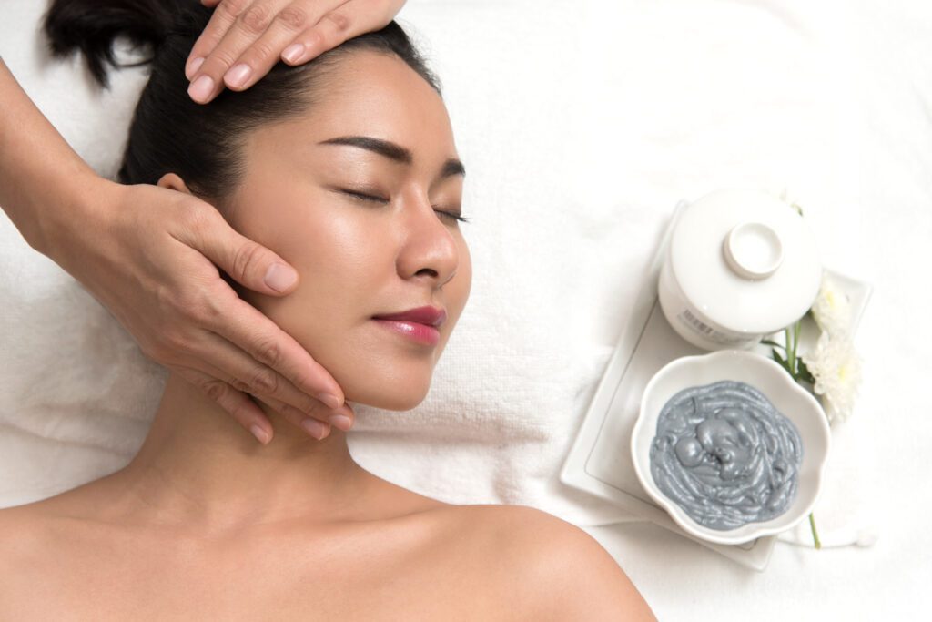 A woman getting her face washed with a towel.