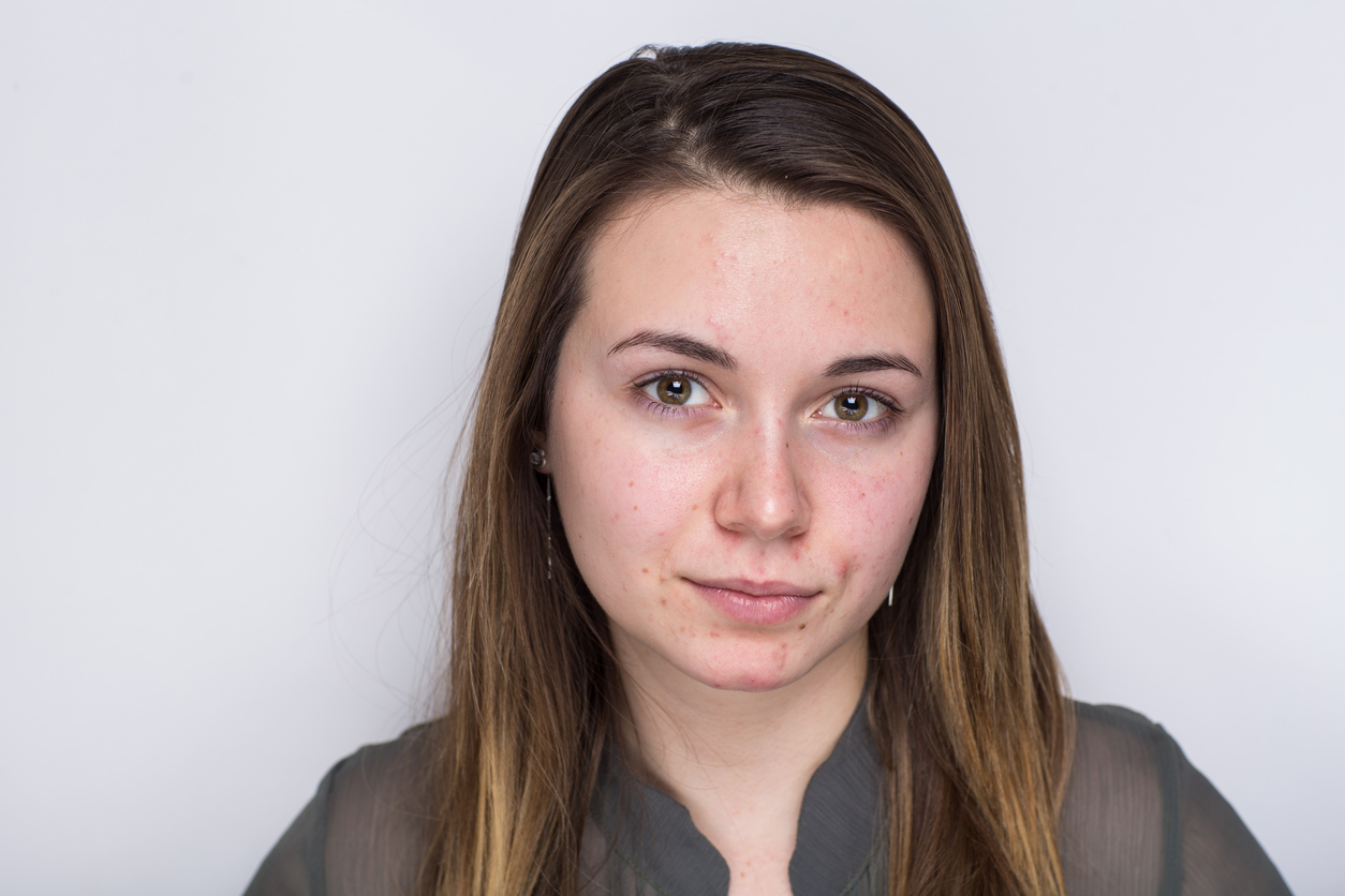 A woman with long hair and a gray shirt.