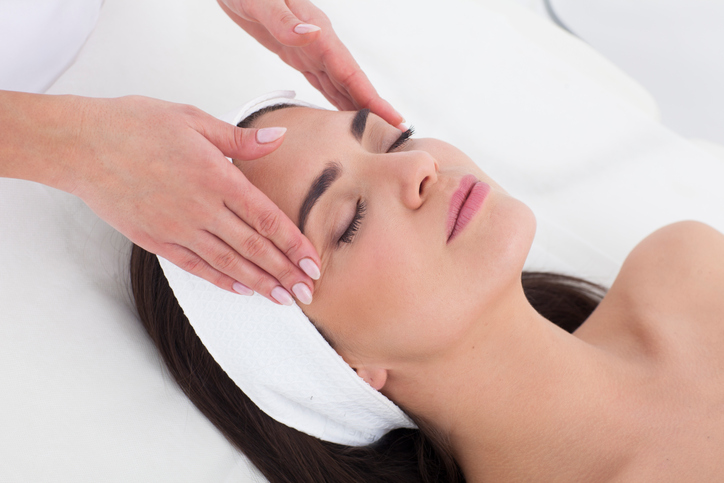 A woman getting her face washed by a hand.