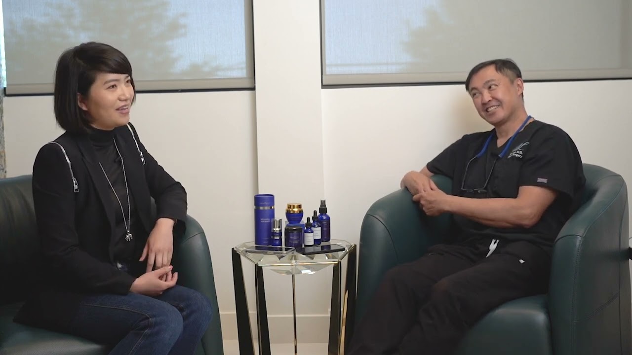 Two people sitting in chairs with a table and some bottles