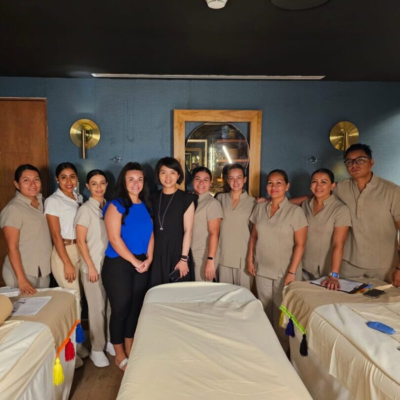 Group of spa staff with massage tables.